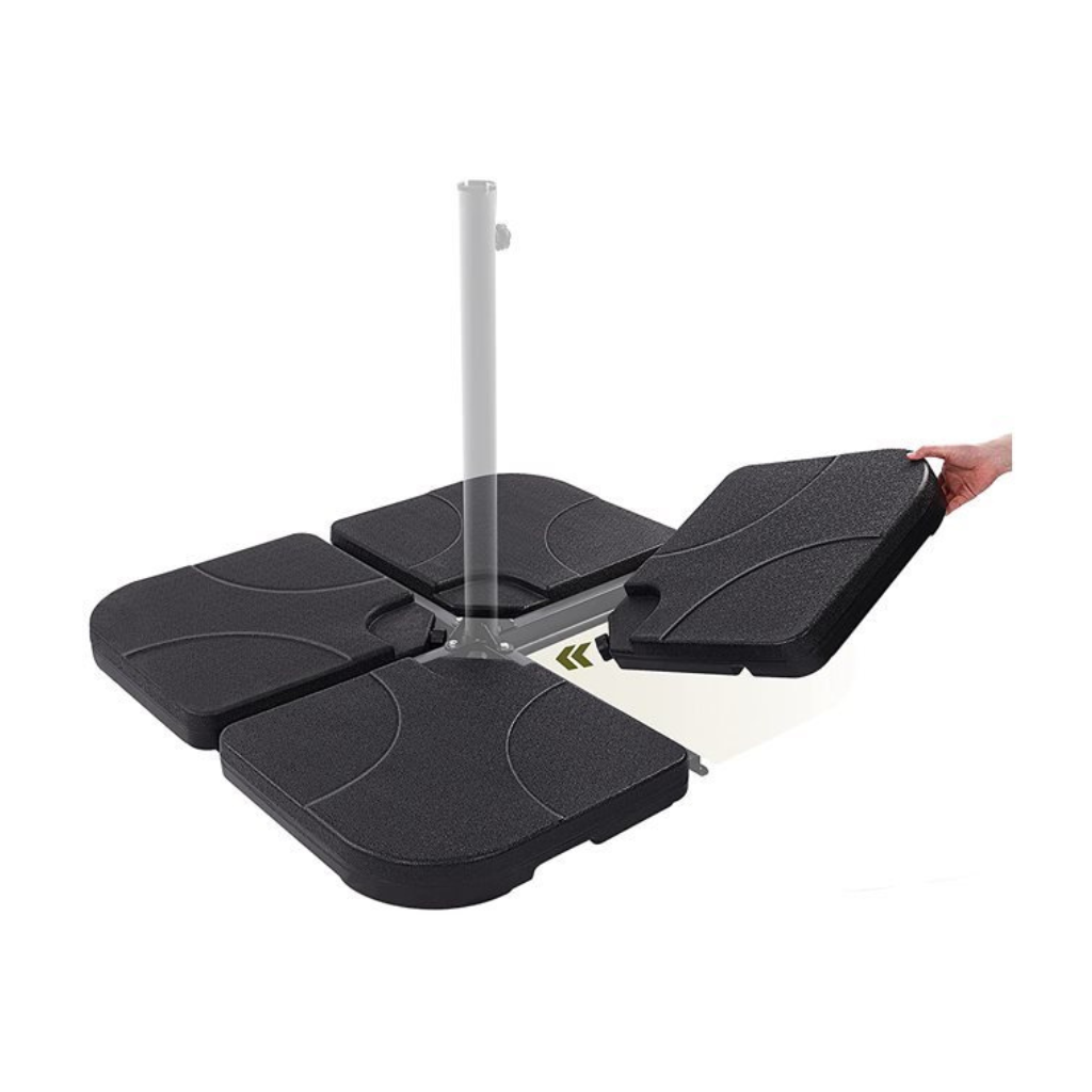Four black fillable parasol base tiles arranged around a metal cross frame, with a hand lifting one tile to show the hollo…