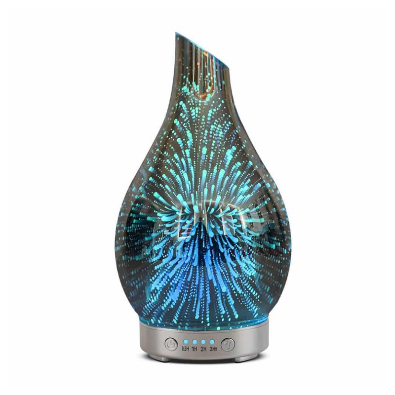 Teardrop-shaped glass aroma diffuser lit with teal-blue 3D fireworks pattern, silver base with timer buttons, white backgr…