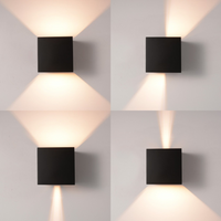 Four-panel grid showing black cube LED wall lamp with different beam angle settings, from wide spread to narrow focused light