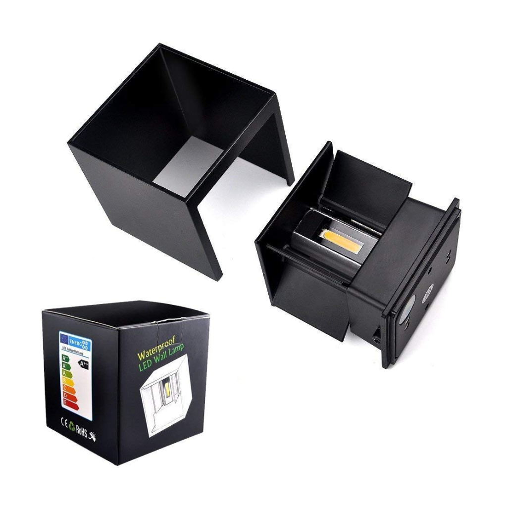 Black cube LED wall lamp disassembled showing housing shell separated from base unit with visible COB LED chip, beside ret…