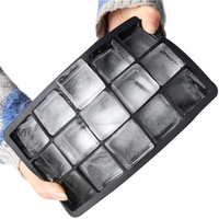 Hands holding a black silicone ice cube tray filled with 15 large clear frozen square cubes, angled top-down view.