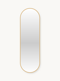 Tall capsule-shaped wall mirror with a thin gold aluminium frame against a light background, front view