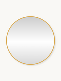 Round wall mirror with slim gold metal frame, front view on off-white background