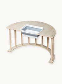 Natural wood semicircular climbing arch table with removable grey and white plastic storage bin fitted through tabletop cu…