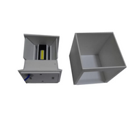Grey cube LED wall lamp housing disassembled: open unit showing COB LED chip and blue wiring beside empty square shell, wh…