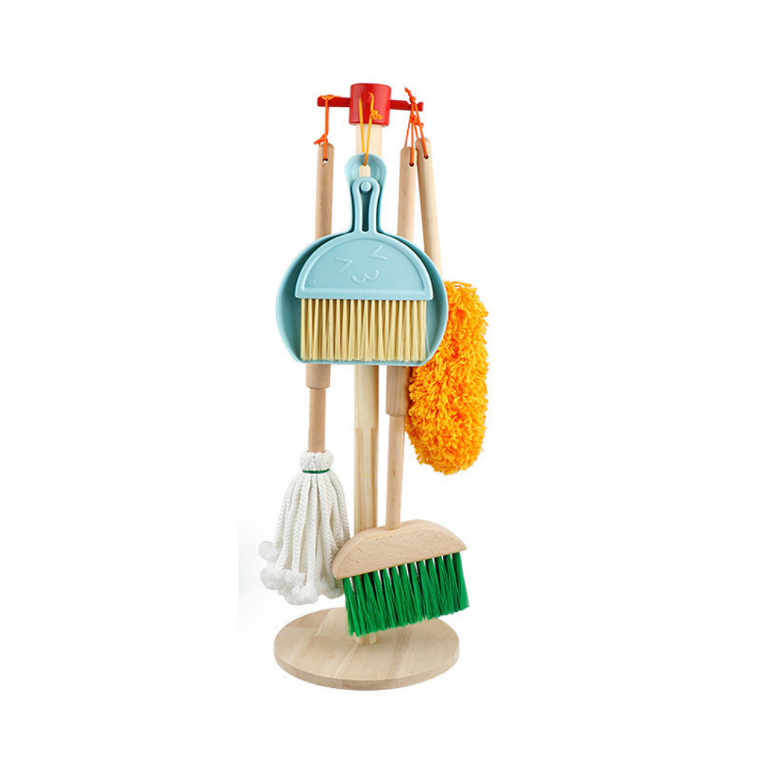 Children's wooden cleaning playset on round stand with blue dustpan, hand brush, white mop, orange duster, and green floor…