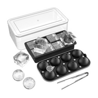 Black silicone ice cube tray set with round and square trays, clear storage container, tongs, and sample ice cubes on whit…