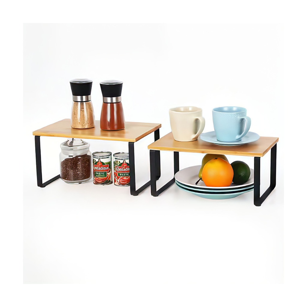Two bamboo-top black metal cabinet risers styled with spice grinders, canned goods, mugs, plates, and fruit