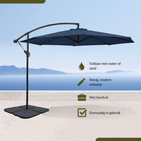 Navy blue cantilever parasol on black cross base with four fillable tiles, displayed against a coastal backdrop with Dutch…