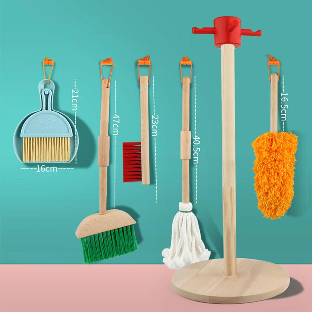 Children's wooden cleaning playset with dimension labels showing broom 47cm, mop 40.5cm, duster 16.5cm, dustpan 21cm, on t…