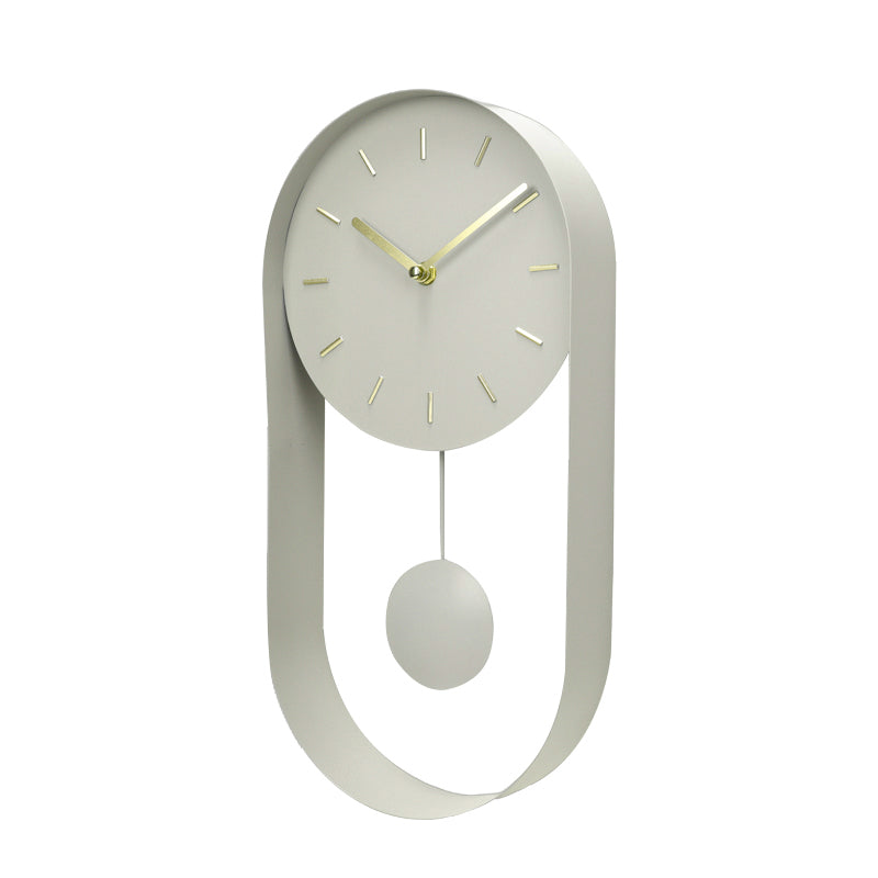 Pale green pendulum wall clock at slight angle, round dial with gold hands, oval open iron frame and spherical bob below