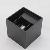 Black matte cube LED wall lamp seen from above at an angle, top open showing internal LED chip and adjustable light direct…