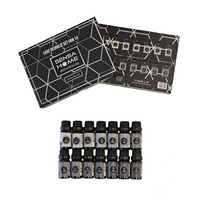 14 SensaHome fragrance oil bottles in two rows with black caps and numbered grey labels, shown below open black gift box l…