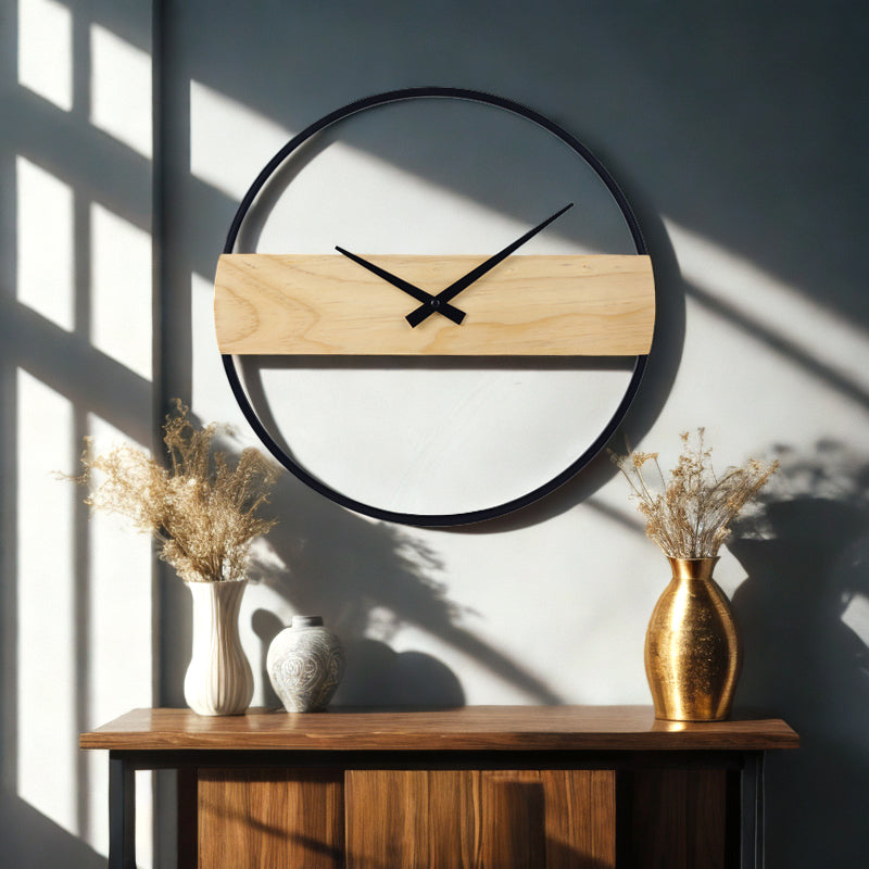 Large Reykjavik wall clock styled above a wooden sideboard with dried floral arrangements, sunlight casting window shadows…