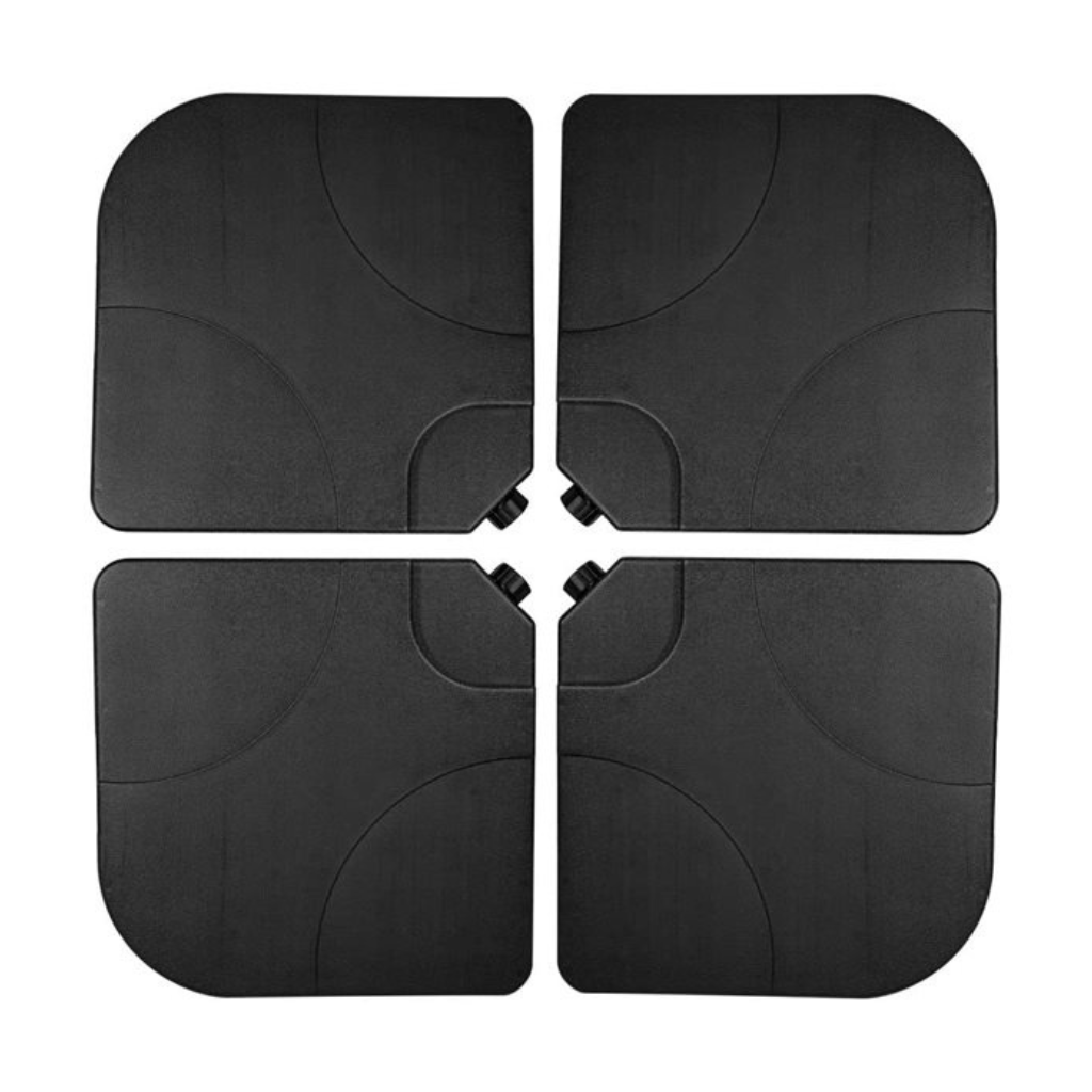 Four black plastic parasol base tiles arranged in a 2x2 grid, showing curved cutouts at centre where pole fits, top-down view