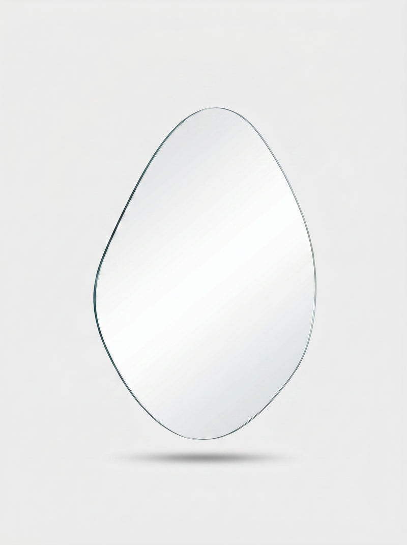 Frameless egg-shaped asymmetric mirror shown floating against light grey background, bevelled glass edge visible, no frame…