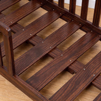Close-up of walnut brown wooden bed base showing screwed wooden slats and frame joinery on light oak flooring