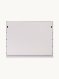 Back of white Hollywood vanity mirror showing pale grey panel, two black hanging hooks, small blue screws around edges, an…