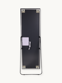 Back panel of LED standing mirror showing black reverse side, white power cable, control box, black easel stand, and corne…