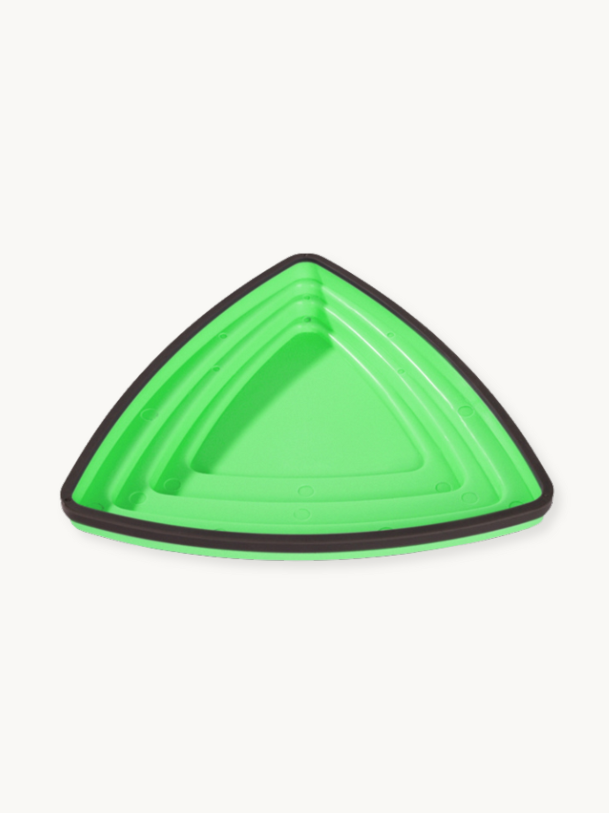 Bright green triangular balance stone, close-up top-down angle showing concentric ridged surface and dark grey rubber bord…