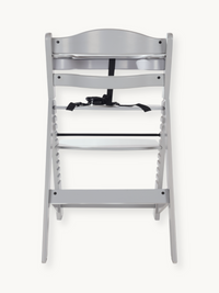 Grey wooden highchair rear view showing slatted back, black 5-point harness, notched adjustable seat and footrest rails