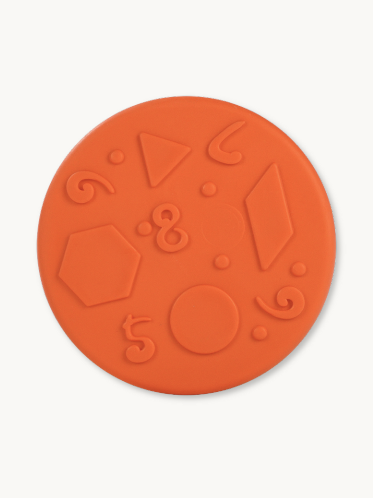 Orange balance disc flat lay showing embossed shapes and numbers including triangle, hexagon, circle, and diamond on textu…