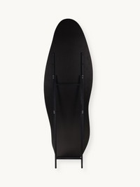 Back view of black asymmetric full-length mirror showing wooden support struts, hinge brackets, and slim black metal easel…