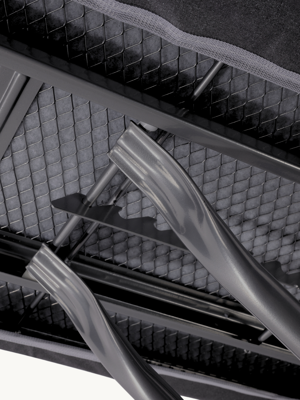 Close-up of ironing board underside showing grey steel cross-frame legs, mesh wire support, and curved iron rest bracket d…