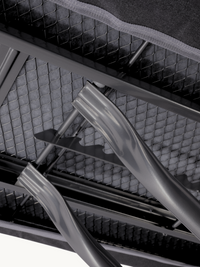 Close-up of ironing board underside showing grey steel cross-frame legs, mesh wire support, and curved iron rest bracket d…