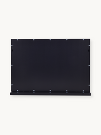 Back panel of black metal Hollywood vanity mirror showing evenly spaced silver screws and a narrow bottom shelf ledge