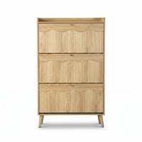 Natural oak shoe cabinet front view, three ribbed flip-down doors with scallop edges, small brass knobs, and angled tapere…