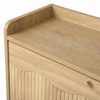 Close-up of natural oak top surface with raised gallery edge and ribbed drawer front with small brass knob below