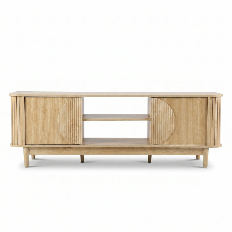 Light oak TV stand front view, ribbed sliding doors with circular detail, two open centre shelves, tapered legs, white bac…