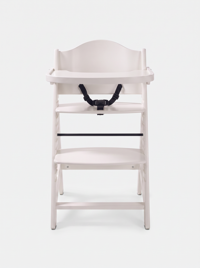 White wooden baby highchair front view, tray attached, black 5-point harness visible, adjustable footrest, plain white bac…