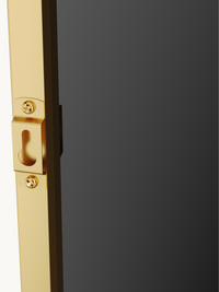 Close-up of gold aluminium frame edge with keyhole wall-mounting bracket and two cross-head screws, dark glass panel visible