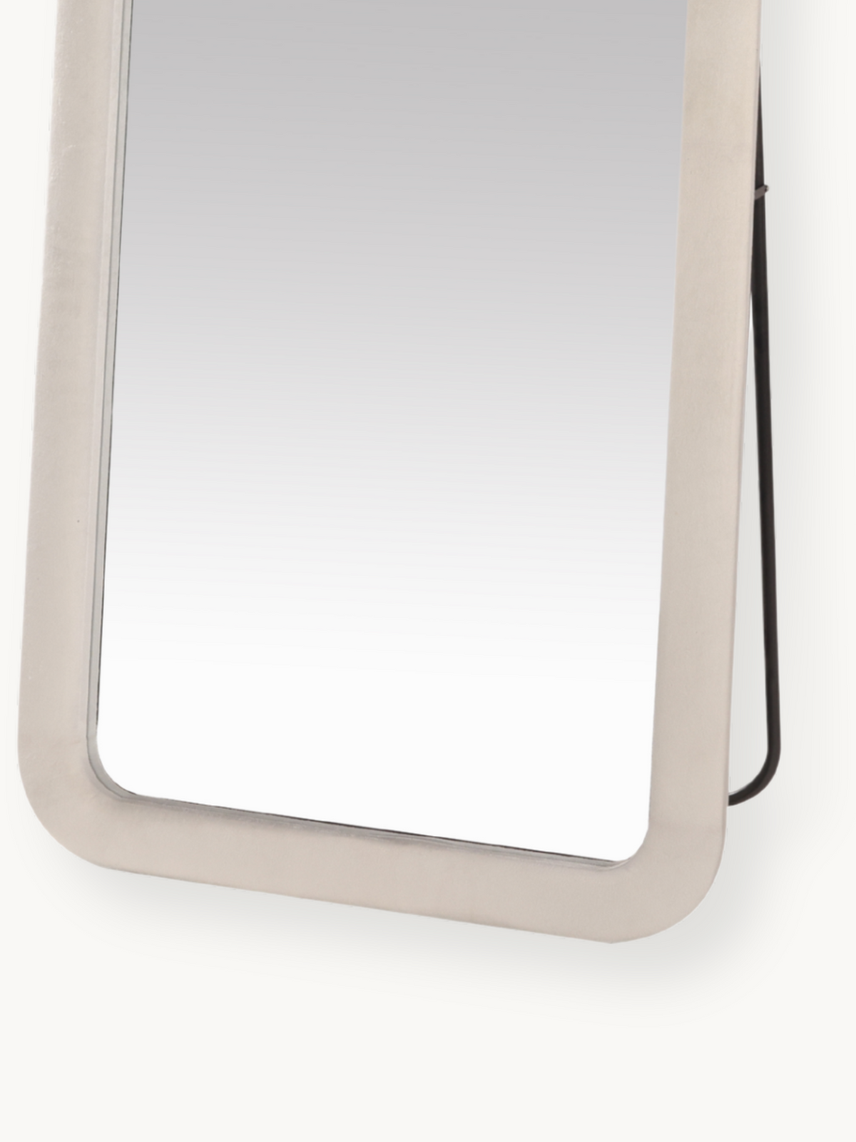 Close-up of lower half of white suede velvet framed standing mirror showing rounded corner detail and black metal back sup…