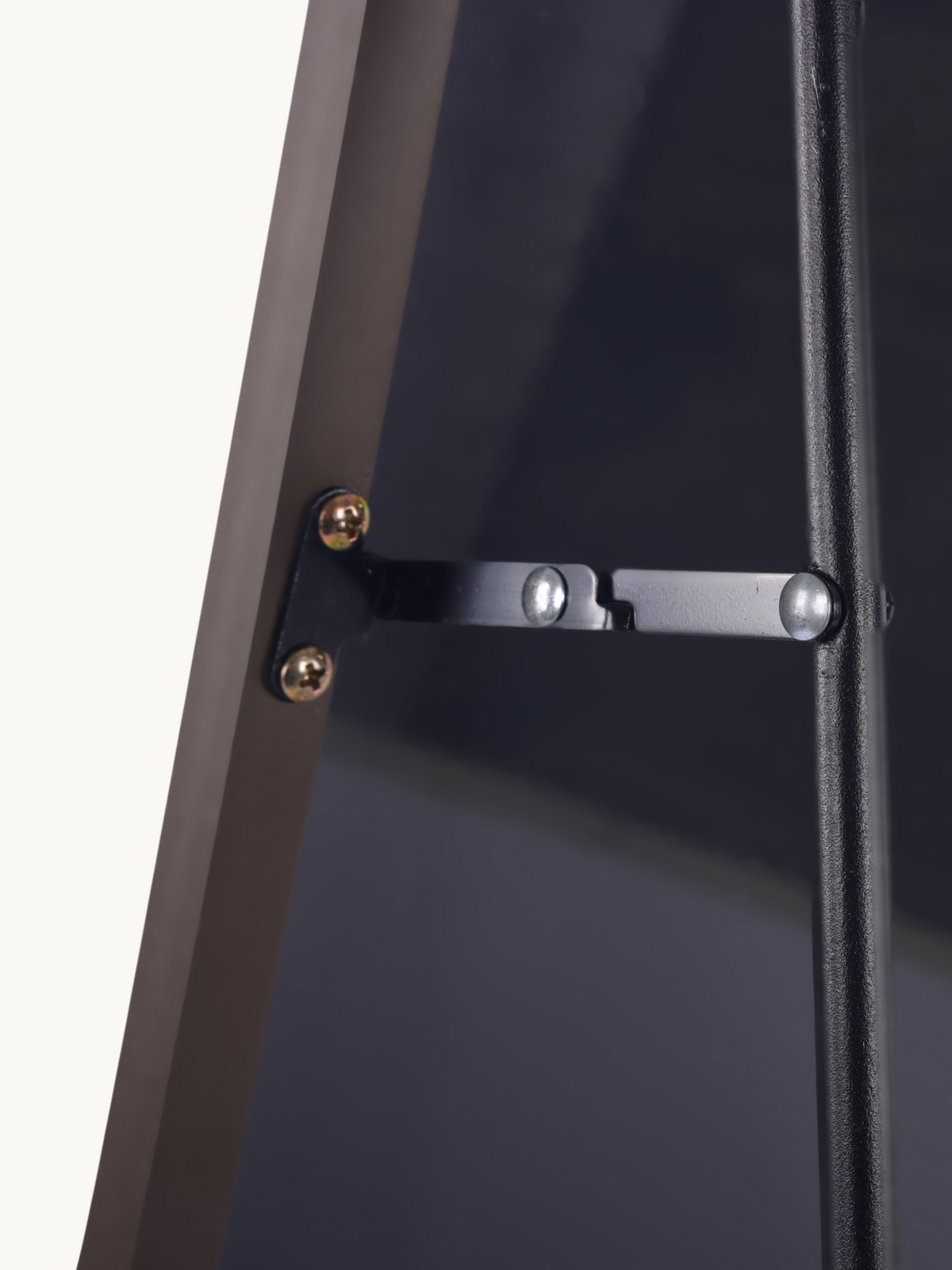 Close-up of metal locking bar and brass screws on the back of a brown aluminium A-frame mirror stand