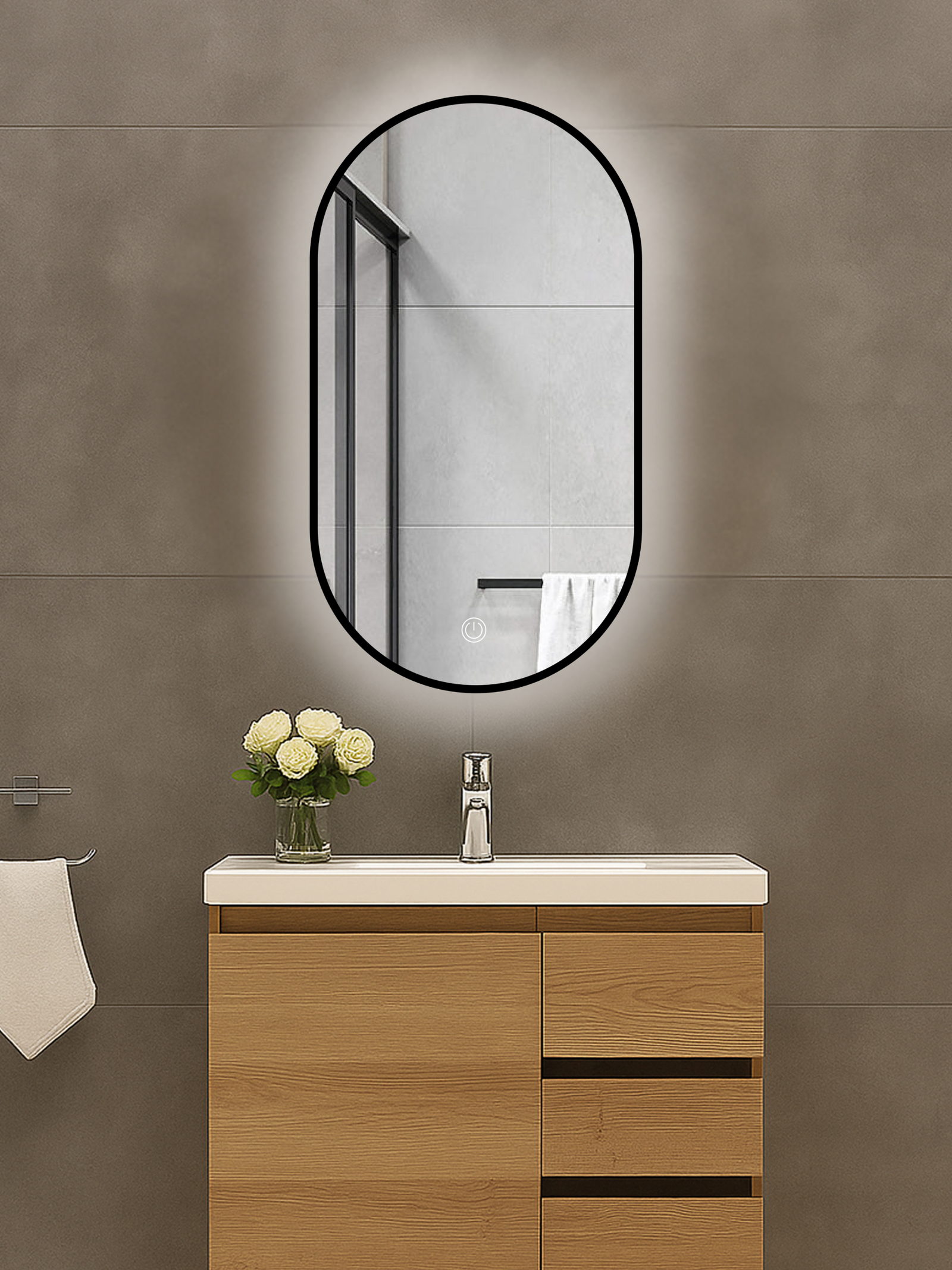 Oval black-framed LED mirror mounted above a wood vanity unit, glowing backlight visible against grey tiled wall, touch co…