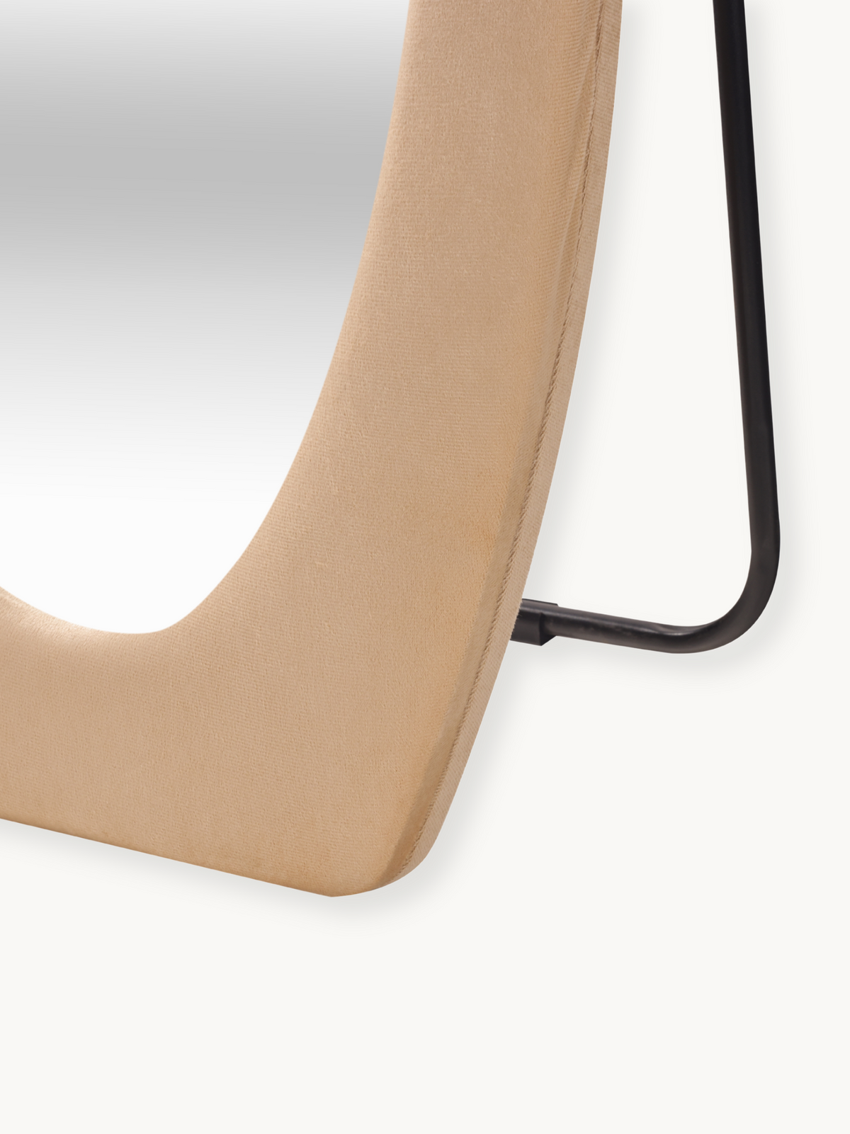 Close-up of curved taupe suede velvet frame edge meeting the black metal stand bracket, showing fabric texture and stitche…