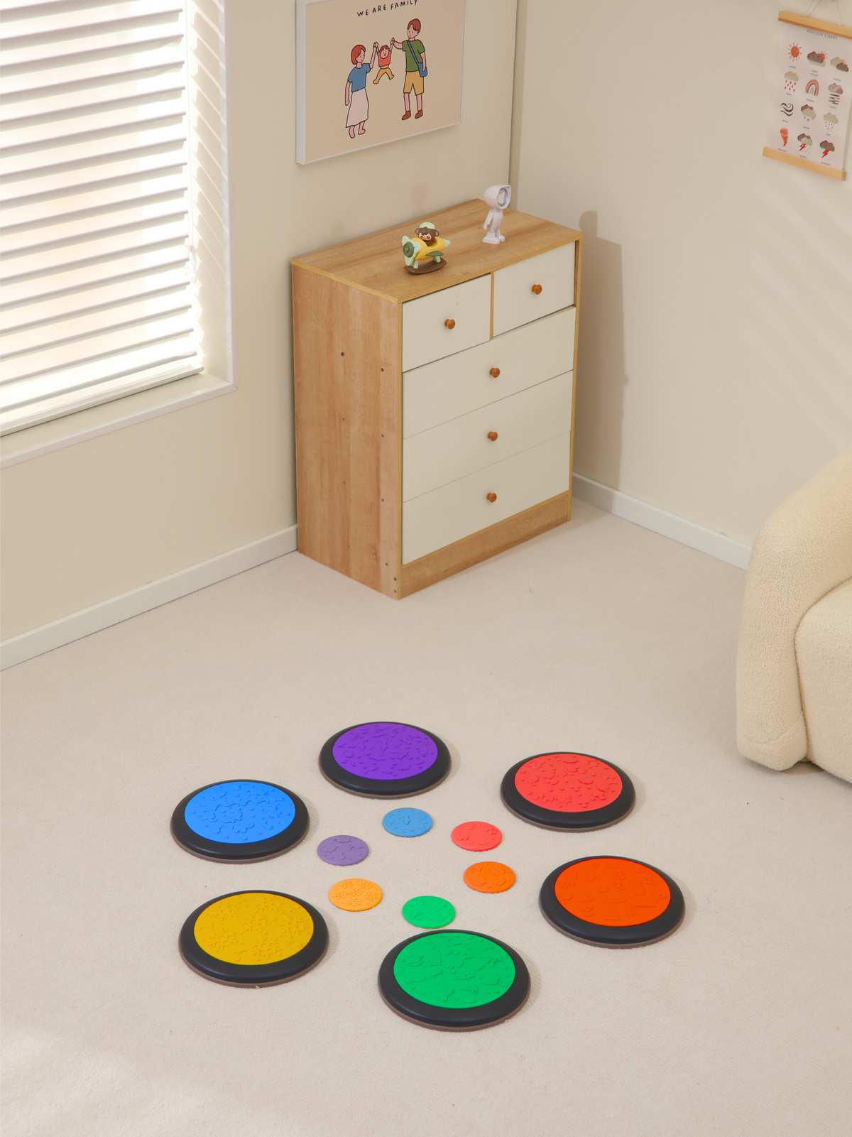 Six multicolor balance discs and six small flat discs arranged loosely on a light floor in a children's bedroom setting