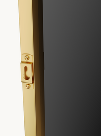 Close-up of polished gold aluminium frame edge showing keyhole wall-hanging bracket with two screws and dark tinted glass…