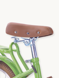 Close-up of tan leather-look saddle with chrome rivets and coil springs on green Ibiza children's bike rear frame