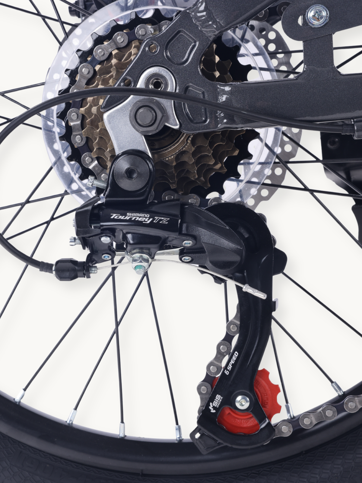 Close-up of Shimano Tourney TZ rear derailleur, 6-speed cassette, disc rotor, and chain on 20-inch wheel