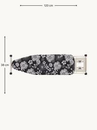 Overhead flat view of ironing board with black and white daisy-print cover, dimension annotations showing 120 cm × 38 cm