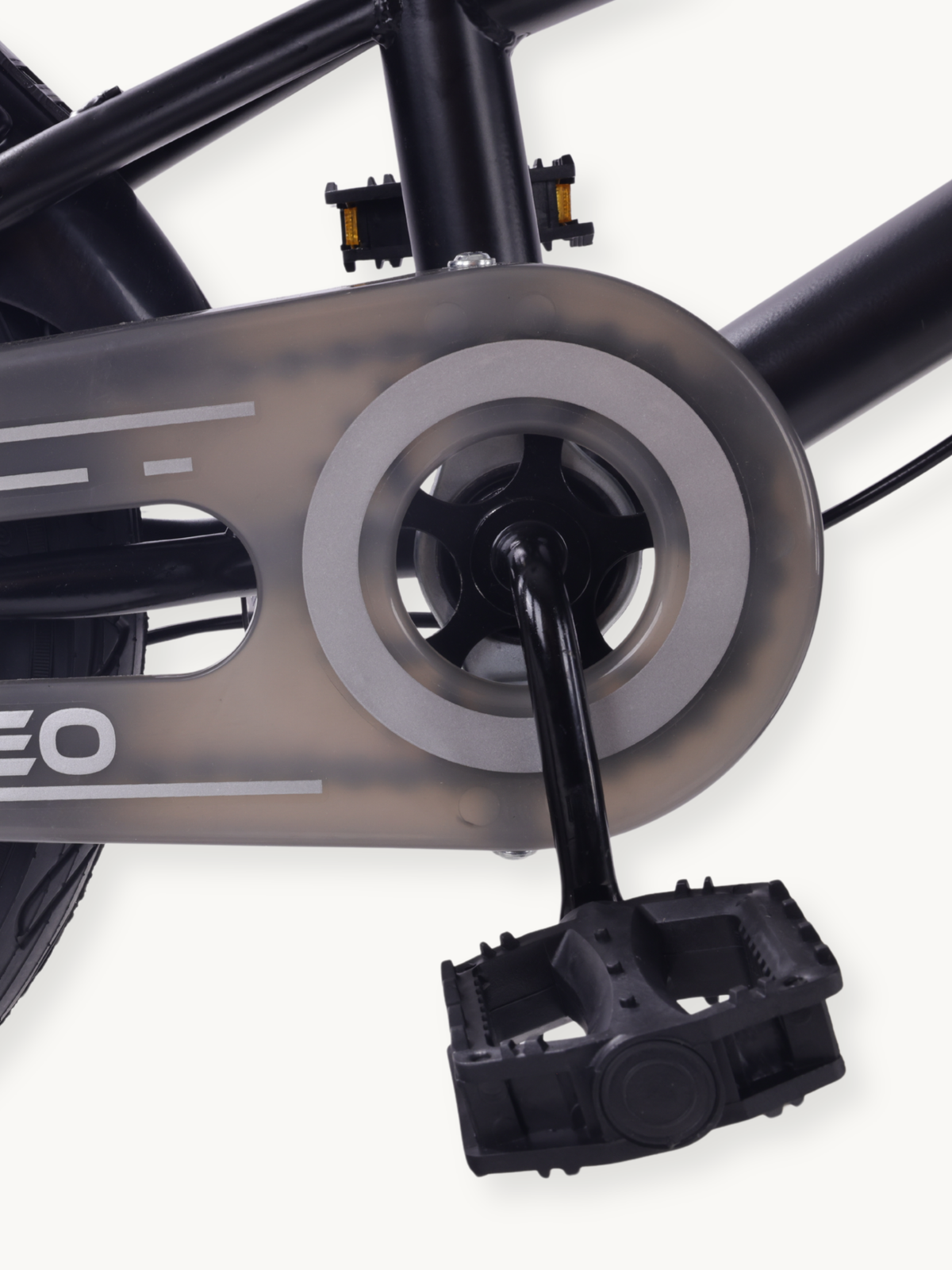 Close-up of black crank, grey chainguard, and black plastic pedal on the Borneo 12-inch kids bike