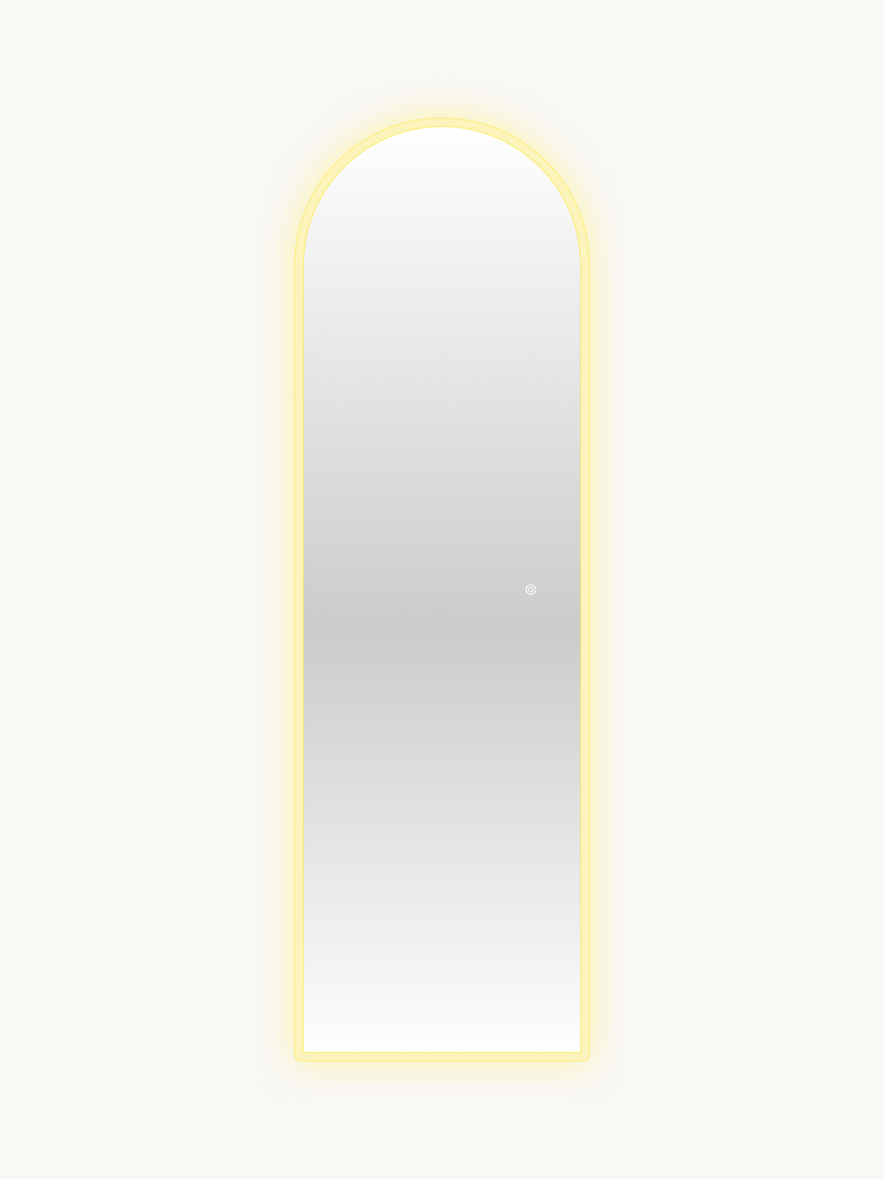 Full-length arched LED mirror with warm yellow perimeter glow illuminated, touch control button visible on glass, front vi…