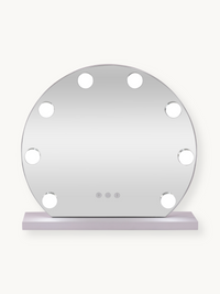 Round white Hollywood vanity mirror with 9 illuminated LED bulbs around the frame and touch controls, on a pale base, fron…