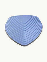 Periwinkle blue triangular balance stone, close-up top-down angle showing concentric ribbed texture and dark grey rubber b…