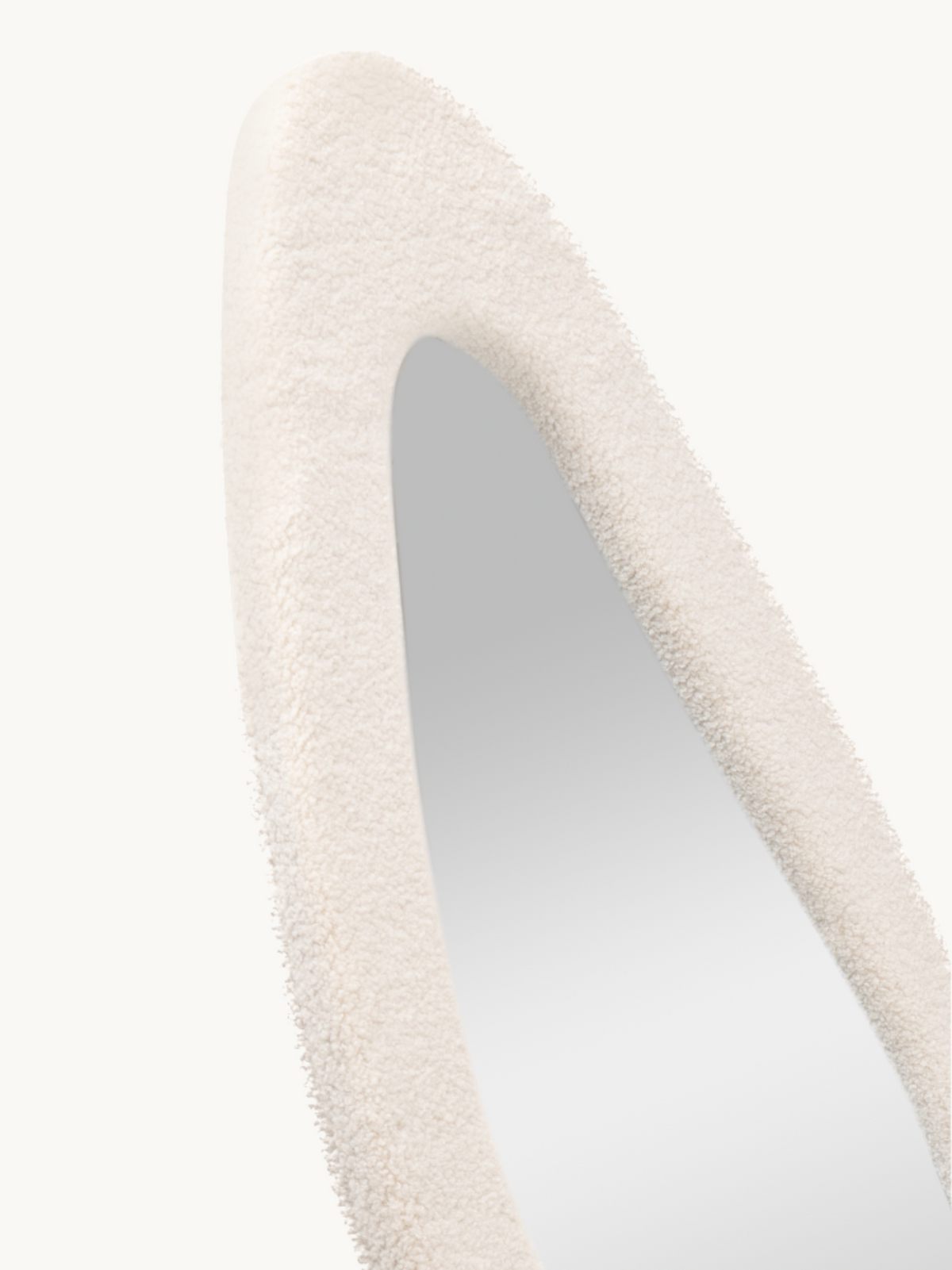Close-up of Seraphina mirror's curved teddy fabric frame top, showing off-white bouclé texture and oval cutout detail