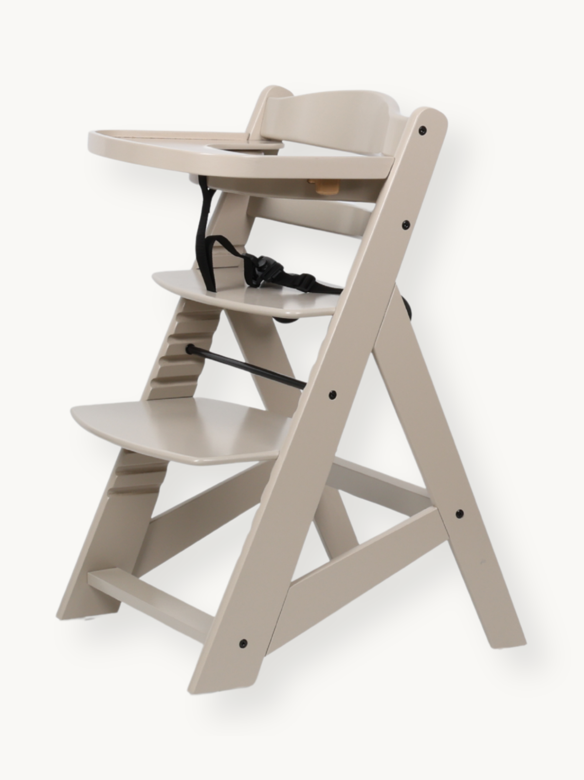 Clay beige wooden highchair three-quarter view, tray attached, black safety harness buckled, adjustable seat and footrest…